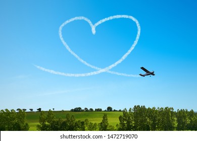 Airplane paints heart in the sky as a symbol of love and wedding
