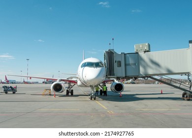 Airplane Parked At The Air Bridge On A Clear Sunny Day