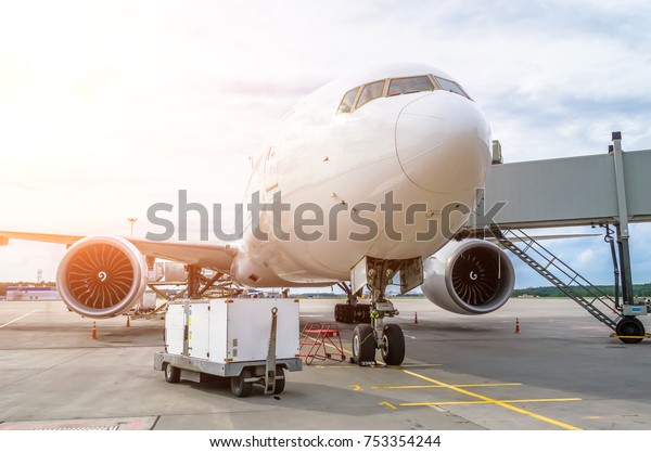 Airplane is parked at the airport with a\
gangway waiting for boarding of\
passengers