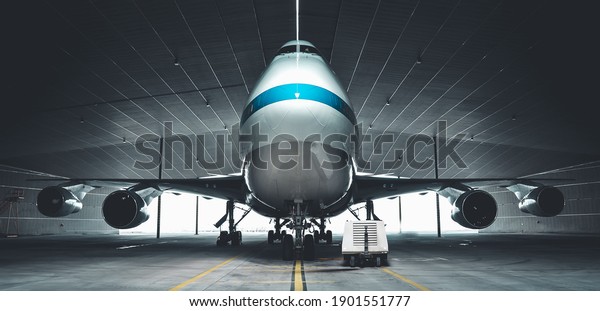 Airplane parking in a hanger inside\
airport . Elements of this image furnished by\
NASA