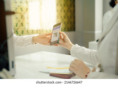 Airplane passenger checking in using electronic boarding pass on phone.