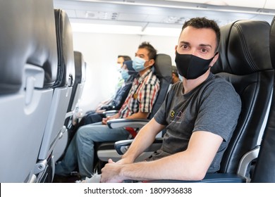 Airplane Passengers Are Wearing Medical Masks On Their Faces. Air Travel During The Coronavirus Pandemic. Airlines Requirements