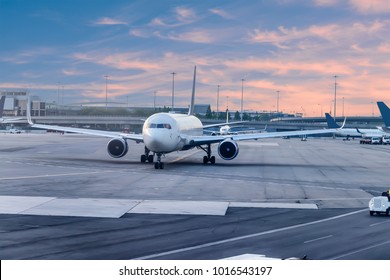 Airplane ready to take off in international airport at sunset