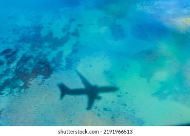 An Airplane Reflected In The Cobalt Blue Sea