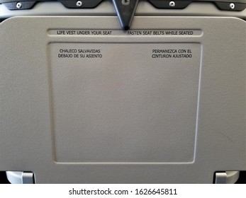 Airplane Seat Back Tray Message About Fastening Seat Belts