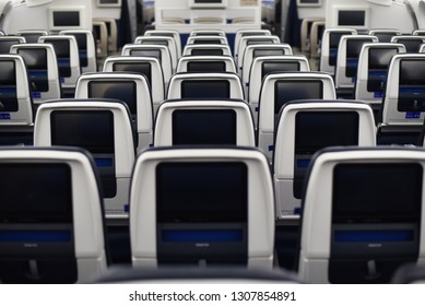  airplane seats viewed from the rear. Inflight entertainment displays