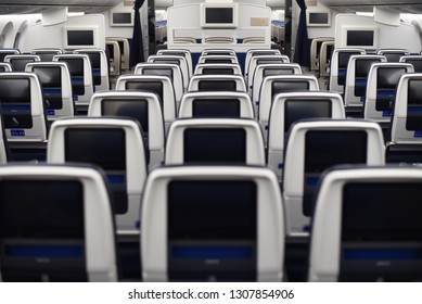   airplane seats viewed from the rear. Inflight entertainment displays.