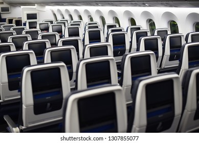  airplane seats viewed from the rear. inflight entertainment displays.