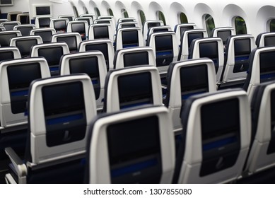  airplane seats viewed from the rear. Inflight entertainment displays.