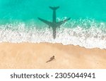 Airplane shadow flying over beautiful exotic tropical beach with woman sunbathing on a sunny cay - Summer vacation travel concept