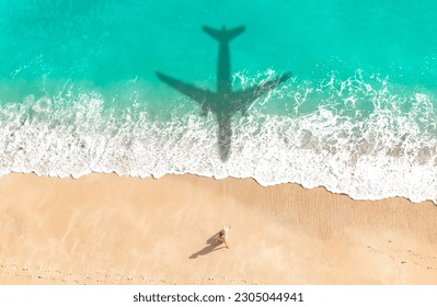 Airplane shadow flying over beautiful exotic tropical beach with woman sunbathing on a sunny cay - Summer vacation travel concept - Powered by Shutterstock
