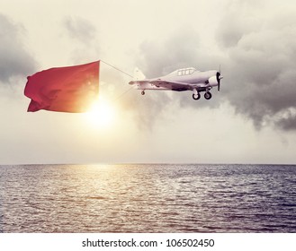 Airplane with a sign above ocean - Shutterstock ID 106502450