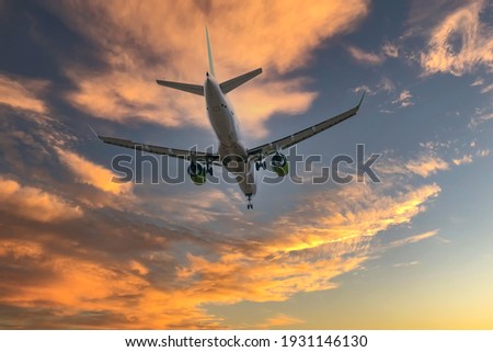 Airplane in the sky at sunrise or sunset