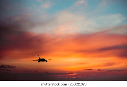 Airplane In The Sky At Sunset