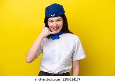 Airplane Stewardess Russian Woman Isolated On Yellow Background Making Phone Gesture. Call Me Back Sign