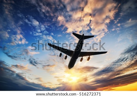 Airplane in sunset sky. 