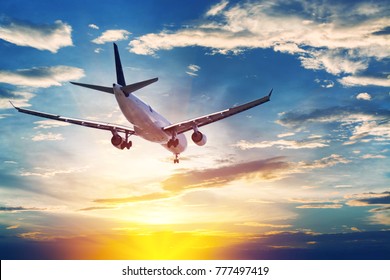 Airplane in the sunset sky flight travel transport airline background concept.
