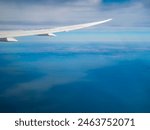 Airplane taken off from Incheon International Airport. Flying above land and water; mountains and sea. View from inside the passenger cabin.