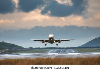 Airplane Taking Off In Summer Day Front View, Horizontal, Rain Clouds On Background/ Plane Fly Up/ Take Off Aircraft From The Airport, Low Over The Runway Vacation, Aviation, Travel, Trip - Concept
