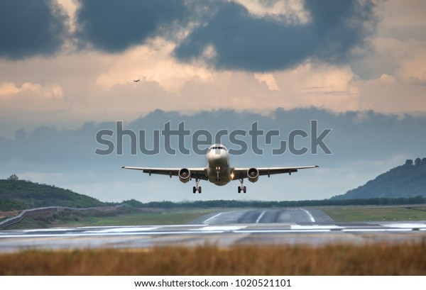 夏の日の前面図で離陸する飛行機 水平 雨雲の背景に飛行機 飛行機 空港から航空機を離陸 滑走路バケーションの低い場所 航空機 旅行 旅行 コンセプト の写真素材 今すぐ編集
