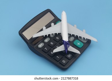 Airplane tickets price, travel budget, cost or expenses concept. Airplane model and calculator on blue background. - Shutterstock ID 2127887318