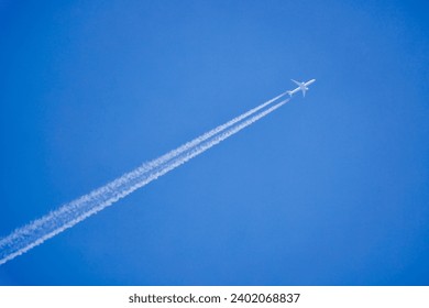 an airplane and the traces it leaves on a blue sky. - Powered by Shutterstock