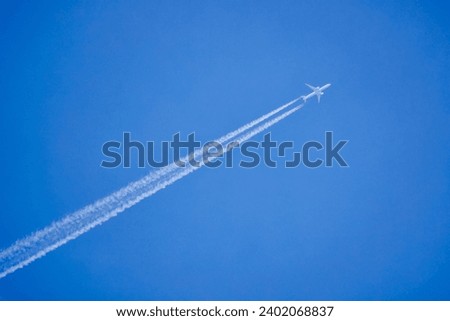 an airplane and the traces it leaves on a blue sky.