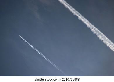 Airplane Trailing White Line On The Dark Blue Sky With A Cloud Formed From Smoke. Color Illustration Photo Of Environmental Pollution, Gas Emissions Or Traveling.