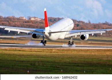 Airplane With Two Engines Landing On Runway Back View - Touchdown With Tire Smoke 