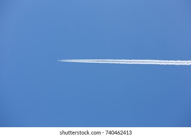 airplane and vapour trail in a clear blue sky