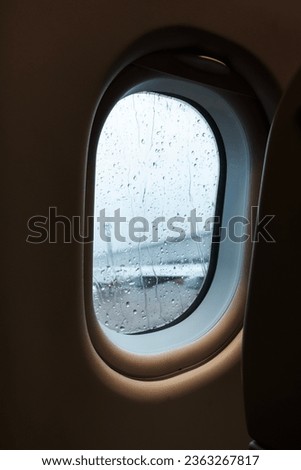 Airplane window and rain drops