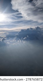 Airplane window view above cloud layers with partial urban landscape of Dublin visible through morning mist at sunrise.