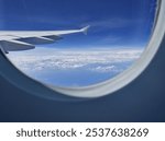 Airplane window view, above the clouds. Stunning sky view from aeroplane window. Great sky view from aircraft window, daylight, sky and clouds. 