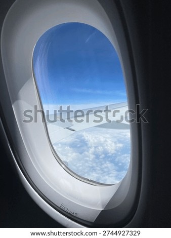 Airplane window view. Airplane view of the mountains. Clouds carpet, cover. Sky and clouds. Sky view.View from sky. from airpplane window. Porthole, window, viewport.