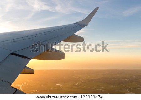 Airplane wing in flight, from window, Sunset sky