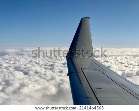Airplane wing flying above the clouds in the morning