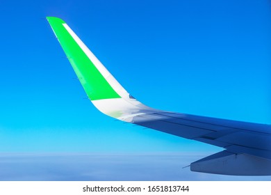 Airplane Wing With Green Stripe. Travel With Eco Friendly Airline. Reducing Carbon Emissions Concept.