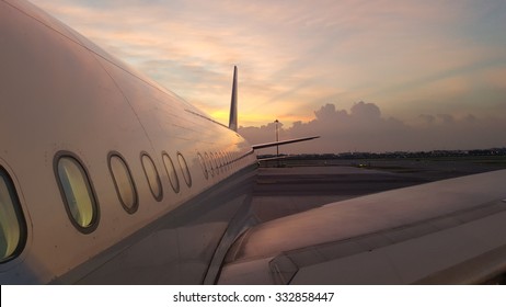airplane wing and tail with the sunset