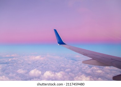 Airplane wing view during sunset with fantastic purple colors.