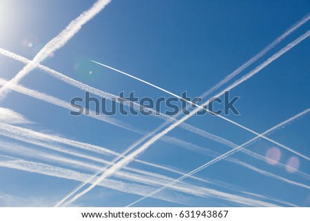 Airplanes in blue sky with Vapor Trail. Condensation trails of planes in the sky. Vertical and horizontal lines in the sky like chessboard or cellular field. Peace. Aviation. Travel concept.