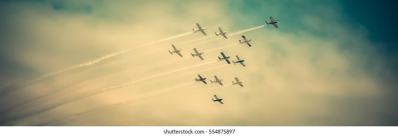 Airplanes flying high, in formation, during airshow, on dramatic sky, vintage effect applied. - Powered by Shutterstock