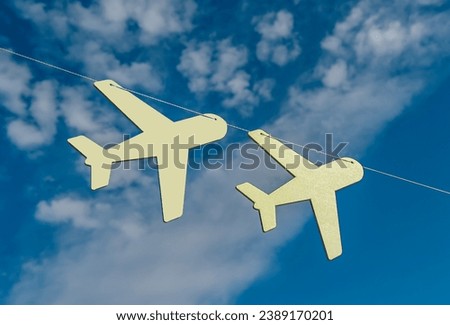 Airplanes hanging on string, rope in blue sky with clouds. Air planes decor