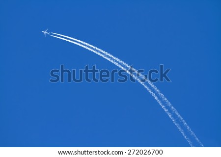 Airplanes leaving arch trace on a clear blue sky.