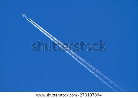 Airplanes leaving diagonal trace on a clear blue sky.