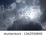 Airplanes on airshow. Aerobatic team performs flight air show. Aviation training institute. Silhouette of an airplane performing acrobatic flight on blue sky. Trace of Smoke behind