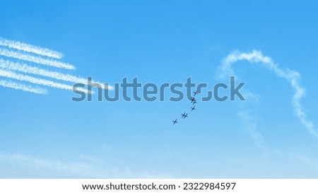 Airplanes on airshow. Aerobatic team performing flight at air show, drawing lines on blue sky.