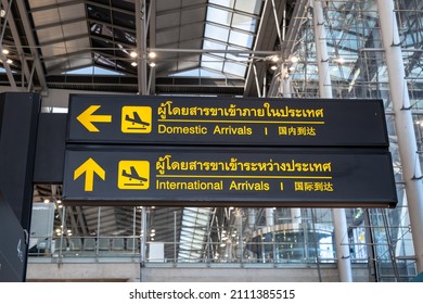 Airport arrival board sign. Flight arrival information board in airport written in English, Chinese and Thai language	