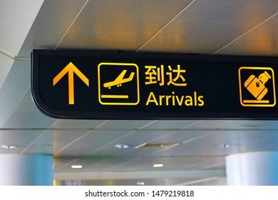 Airport Arrival sign with Chinese wording on top.