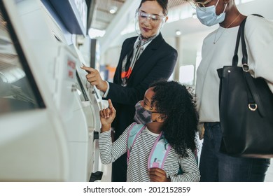 Airport Attendant Helping  Family Of Two Doing Self Check-in. Young Girl And Woman Taking Help Of Airport Staff At International Terminal.