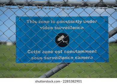 Airport Environment - Airport fence with a warning sign in English and French language 